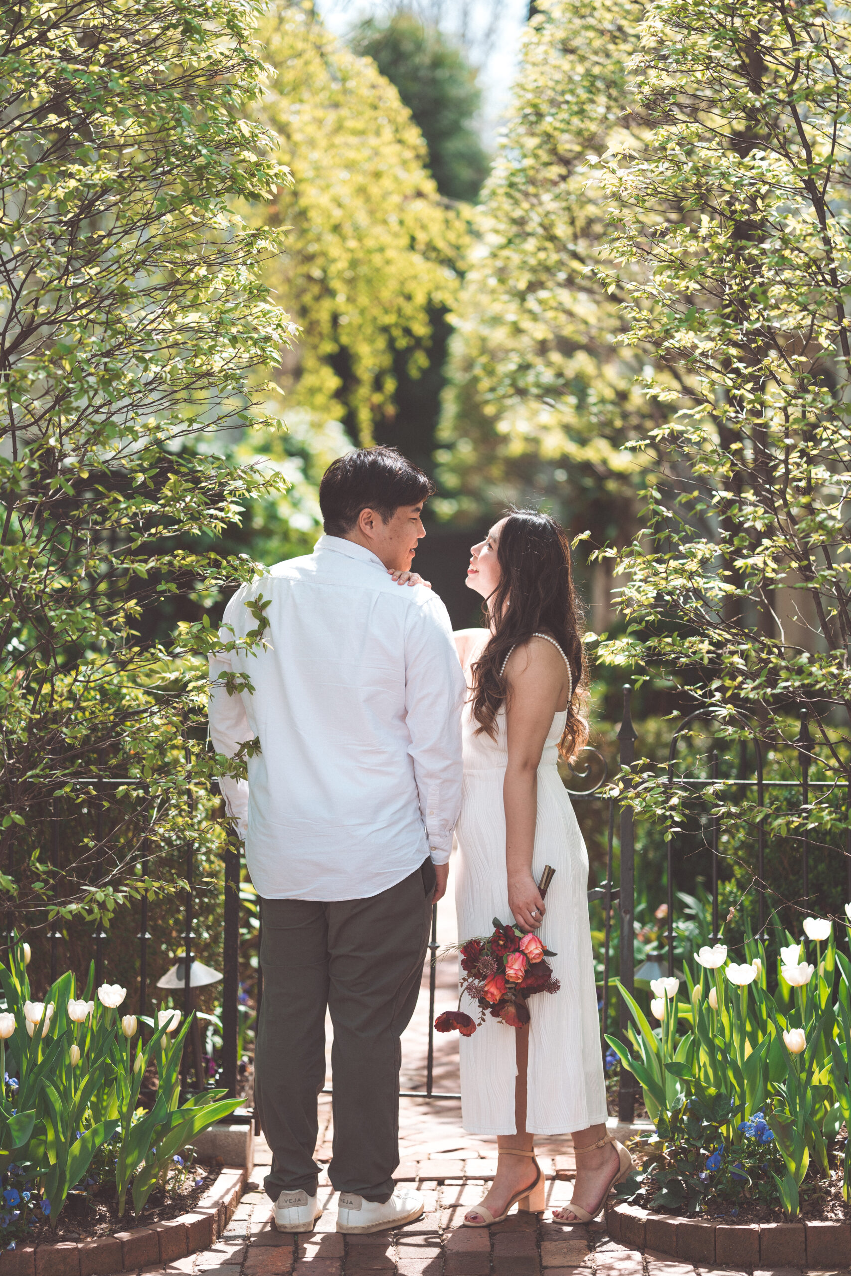 Intimate portrait of couple standing in a lush garden with florals during a Washington DC engagement shoot