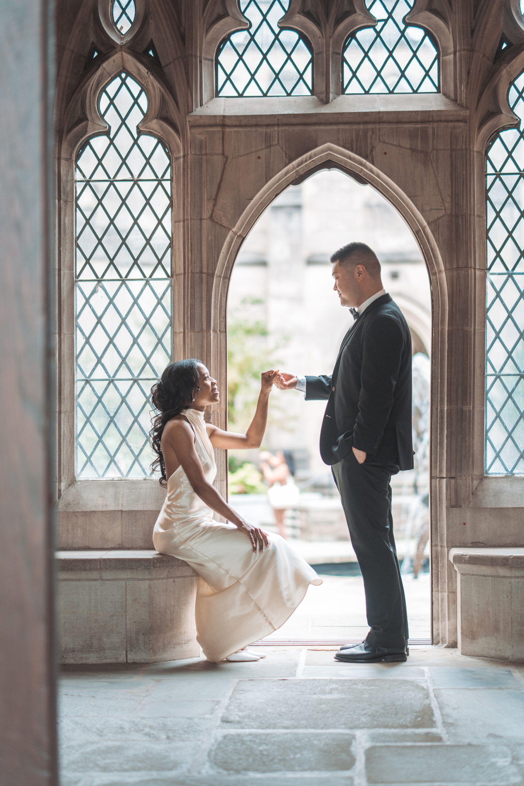 Elegant portrait of couple framed by gothic windows inside a historic Washington DC architectural landmark