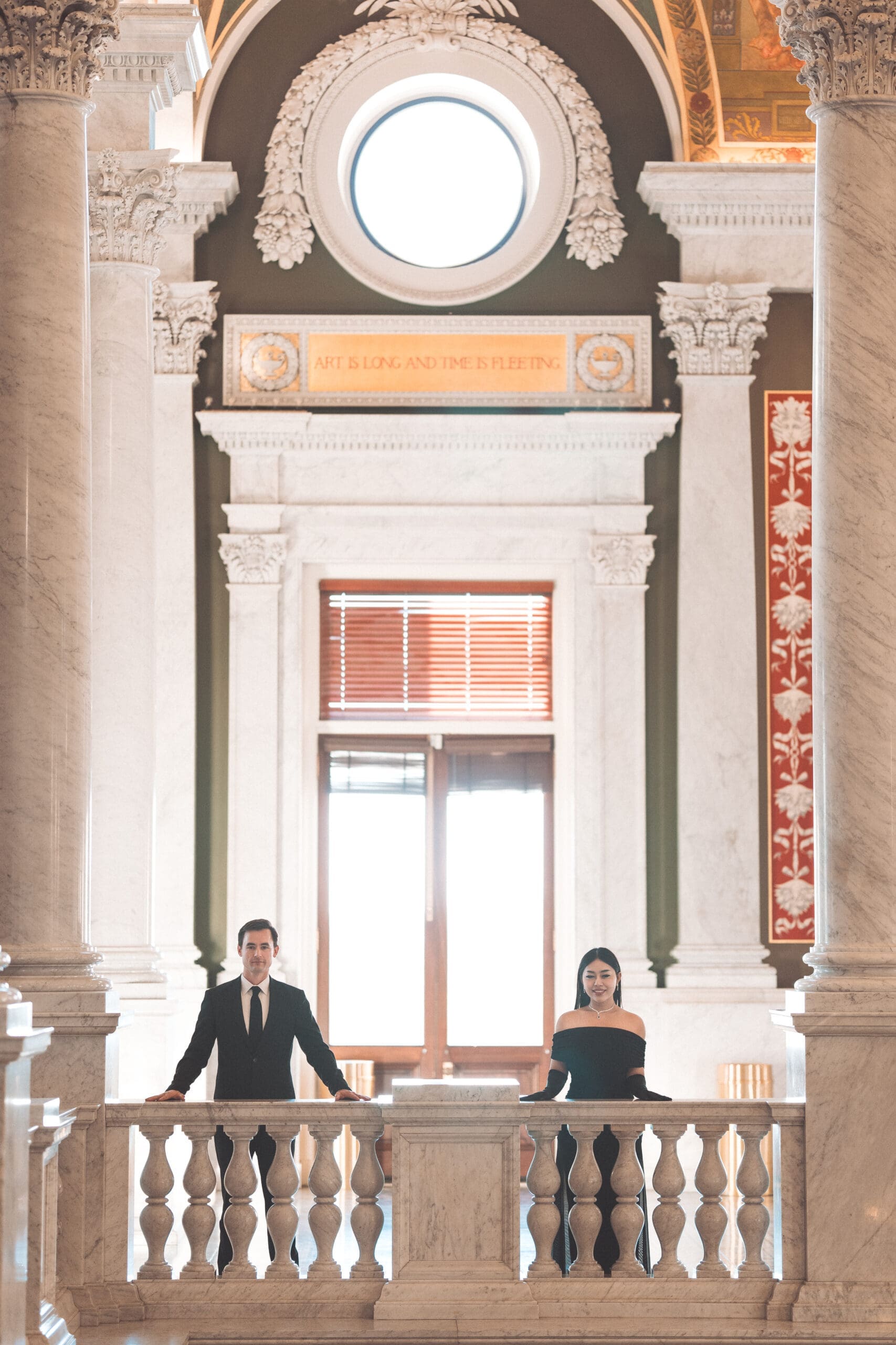 Elegant couple posing inside a historic Washington DC building with grand marble architecture and natural light