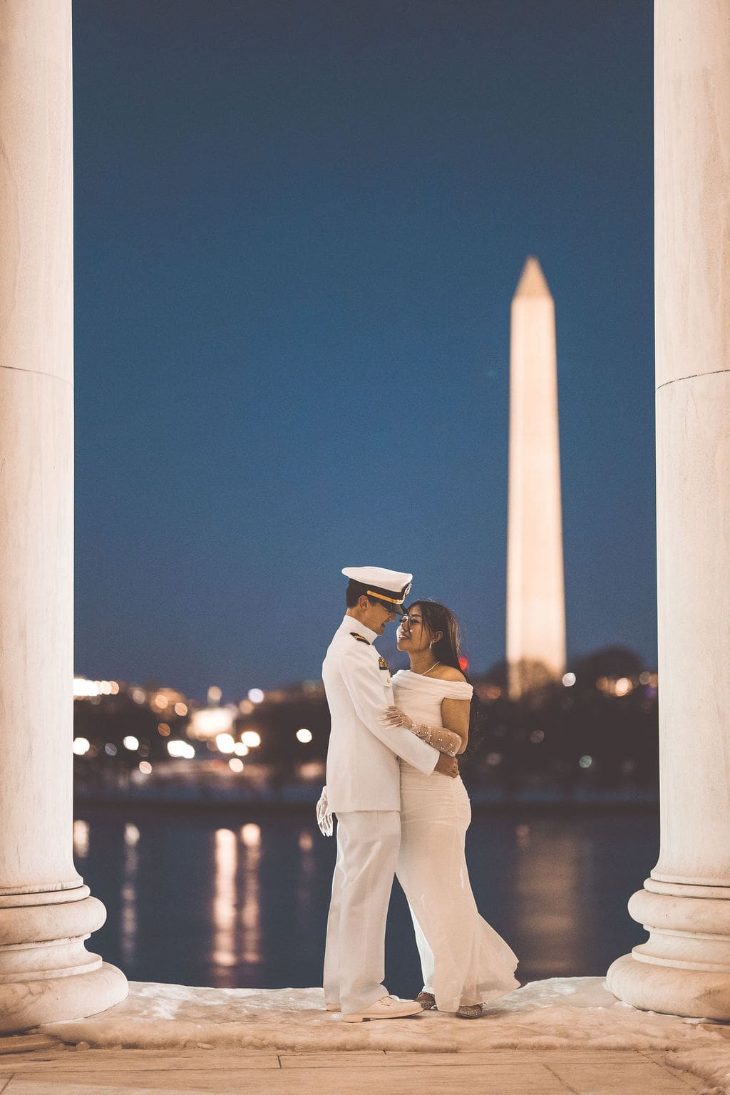 Romantic Washington DC engagement portrait at the Jefferson Memorial with the Washington Monument reflected across the water during nightime