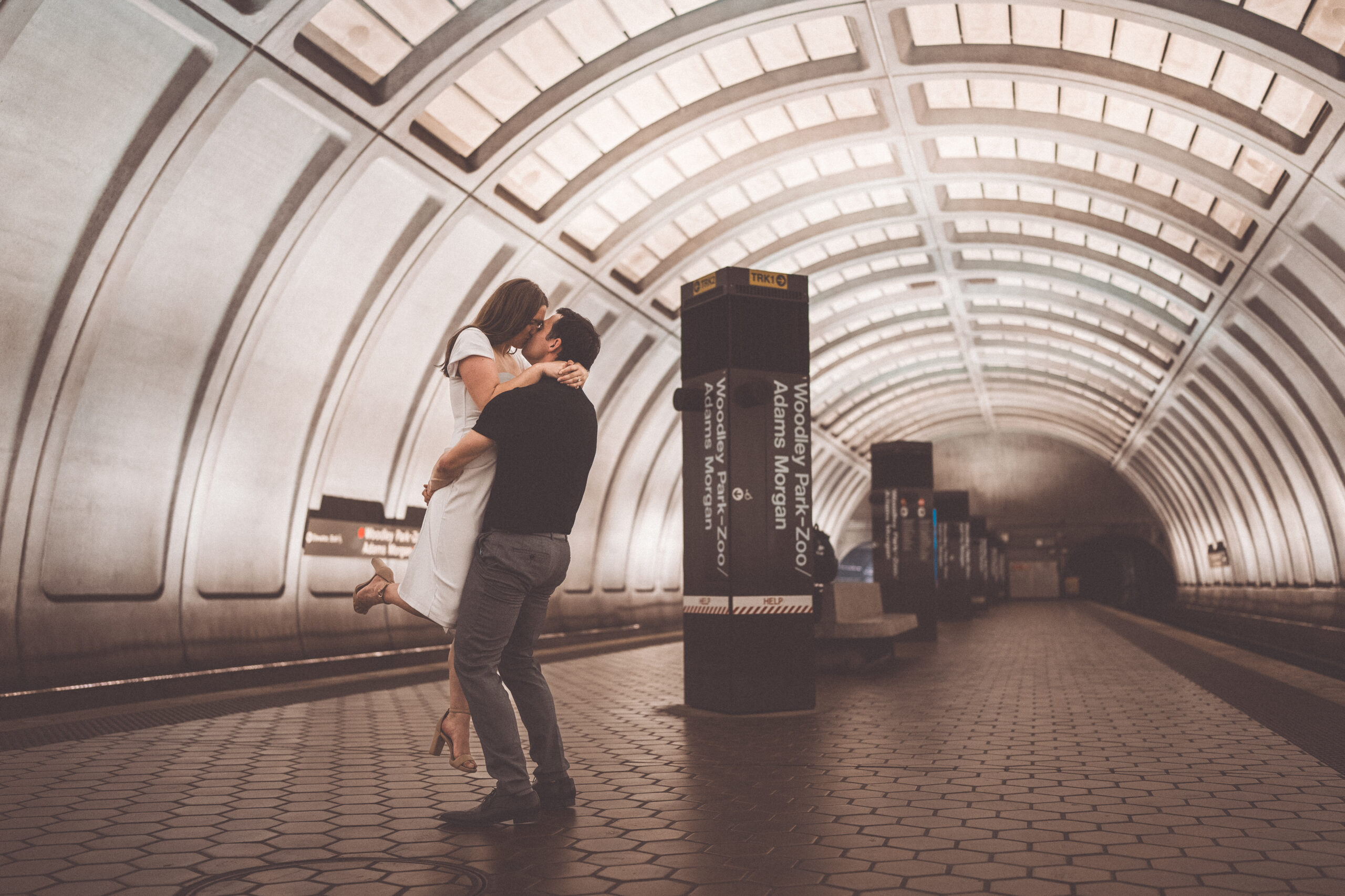 Romantic Washington DC engagement photos of a couple embracing and kissing inside the Woodley Park Metro station