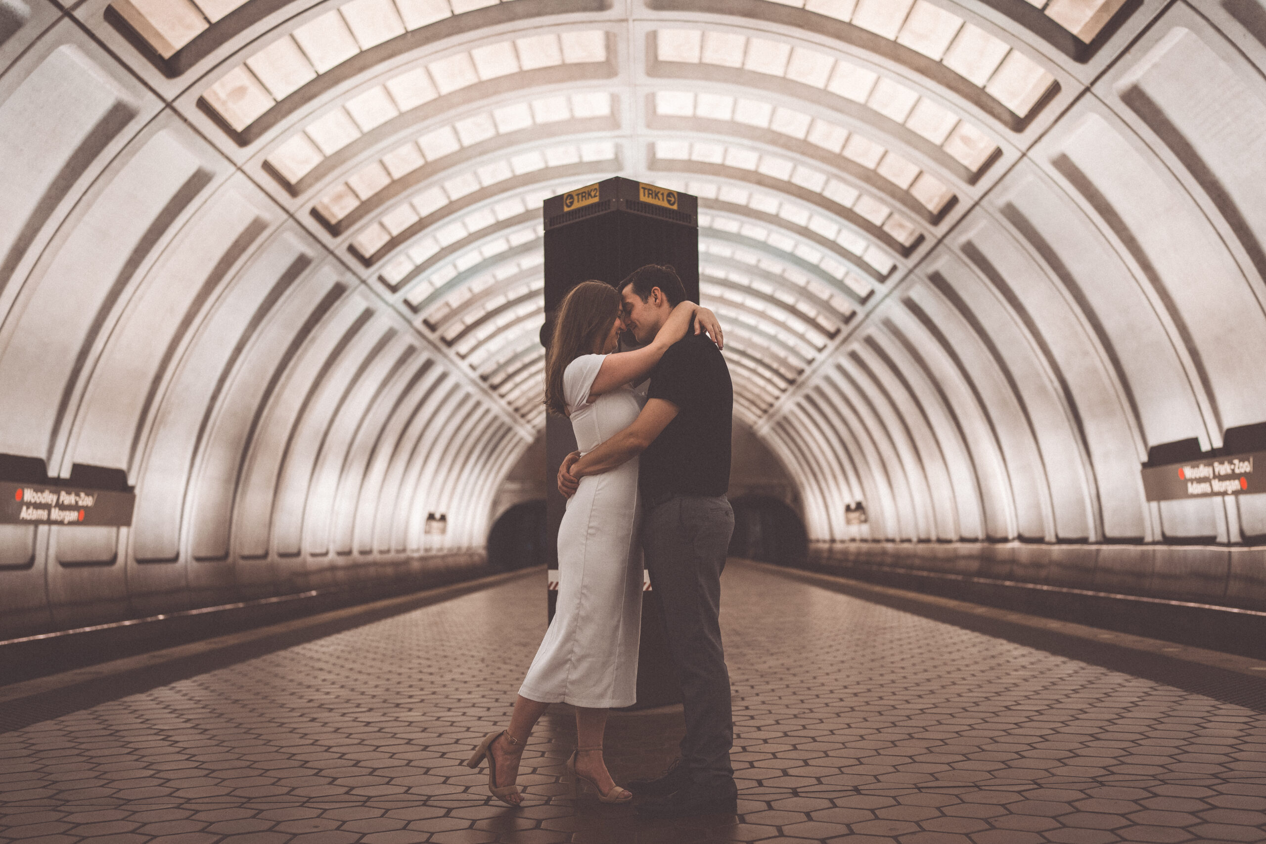 Romantic Washington DC engagement photos of a couple embracing and kissing inside the Woodley Park Metro station