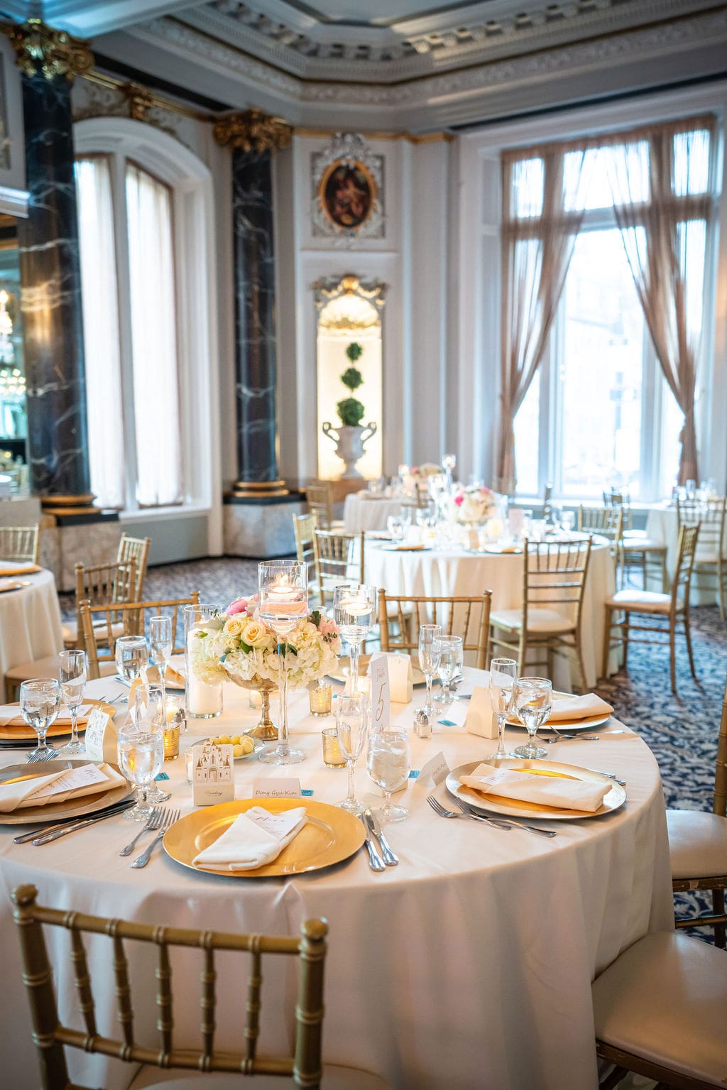 Elegant wedding reception tablescape inside The Belvedere Maryland with chandeliers and classic ballroom details.