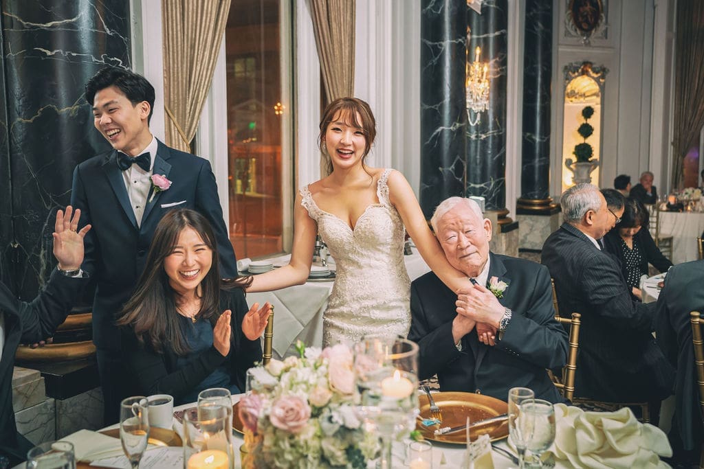 Bride, groom, and family members smiling together during a joyful wedding reception at The Belvedere Maryland.