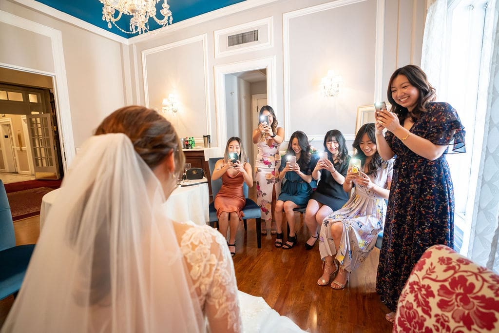 Bridesmaids reacting during a bridal reveal while taking photos of the bride before the ceremony at The Belvedere Maryland.