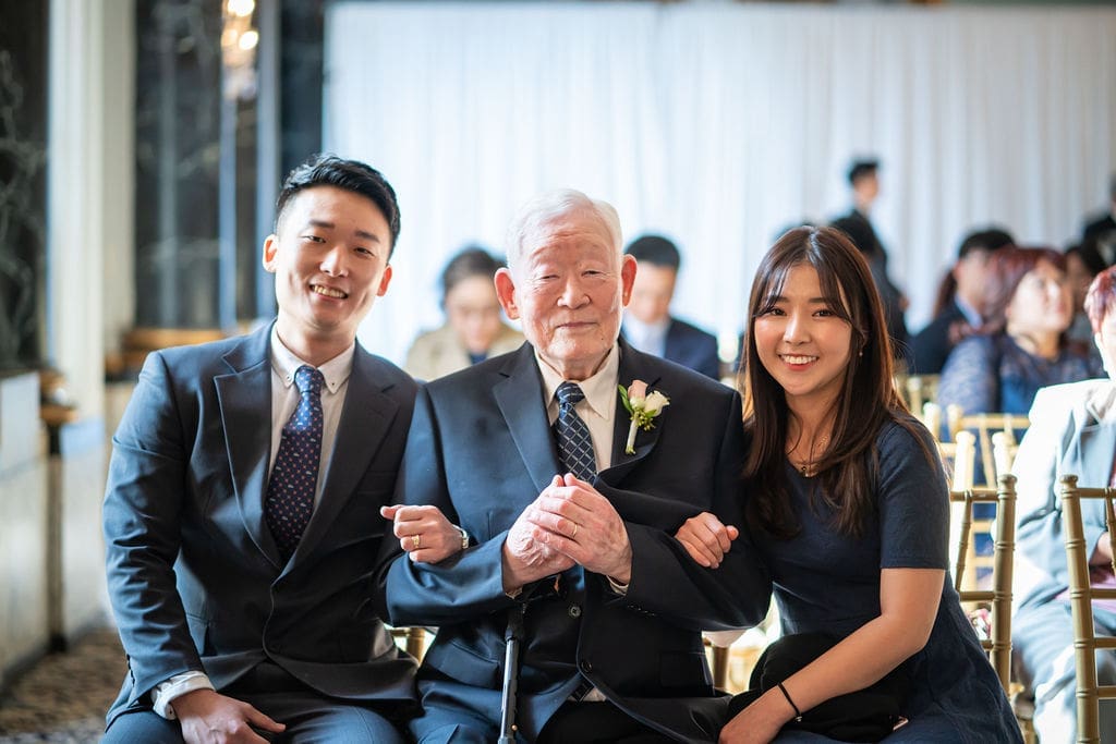The brides grandfather, brother, and sister share smiles for a family portrait during reception.