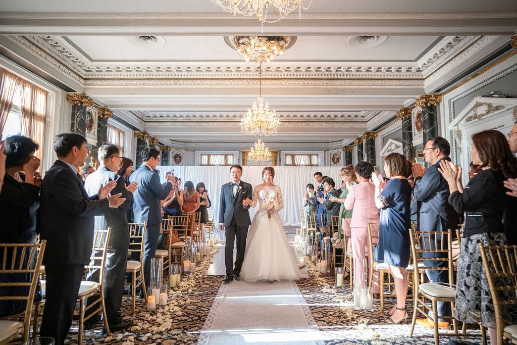 Bride walking down the aisle with her father during an elegant wedding ceremony at The Belvedere Maryland.
