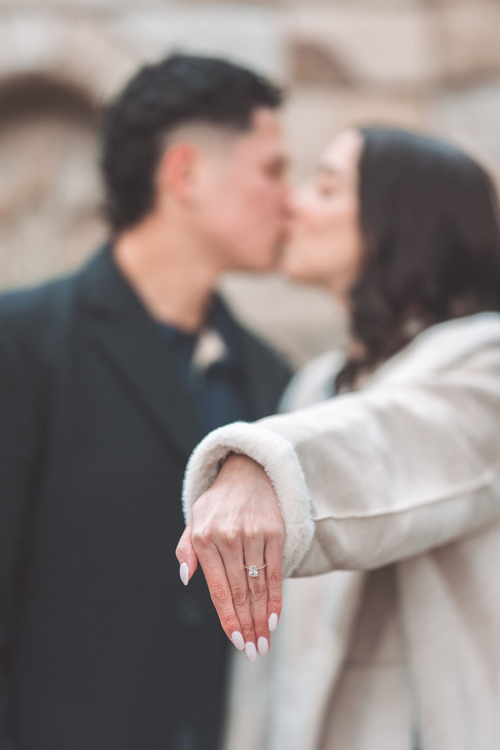 Washington DC proposal ring photo with the couple sharing a kiss softly blurred in the background.