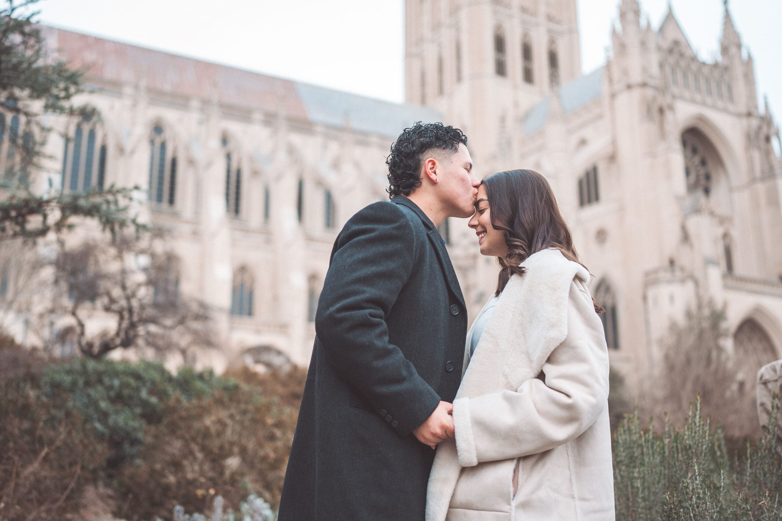 Close-up portrait of a newly engaged couple smiling together outside Washington National Cathedral.