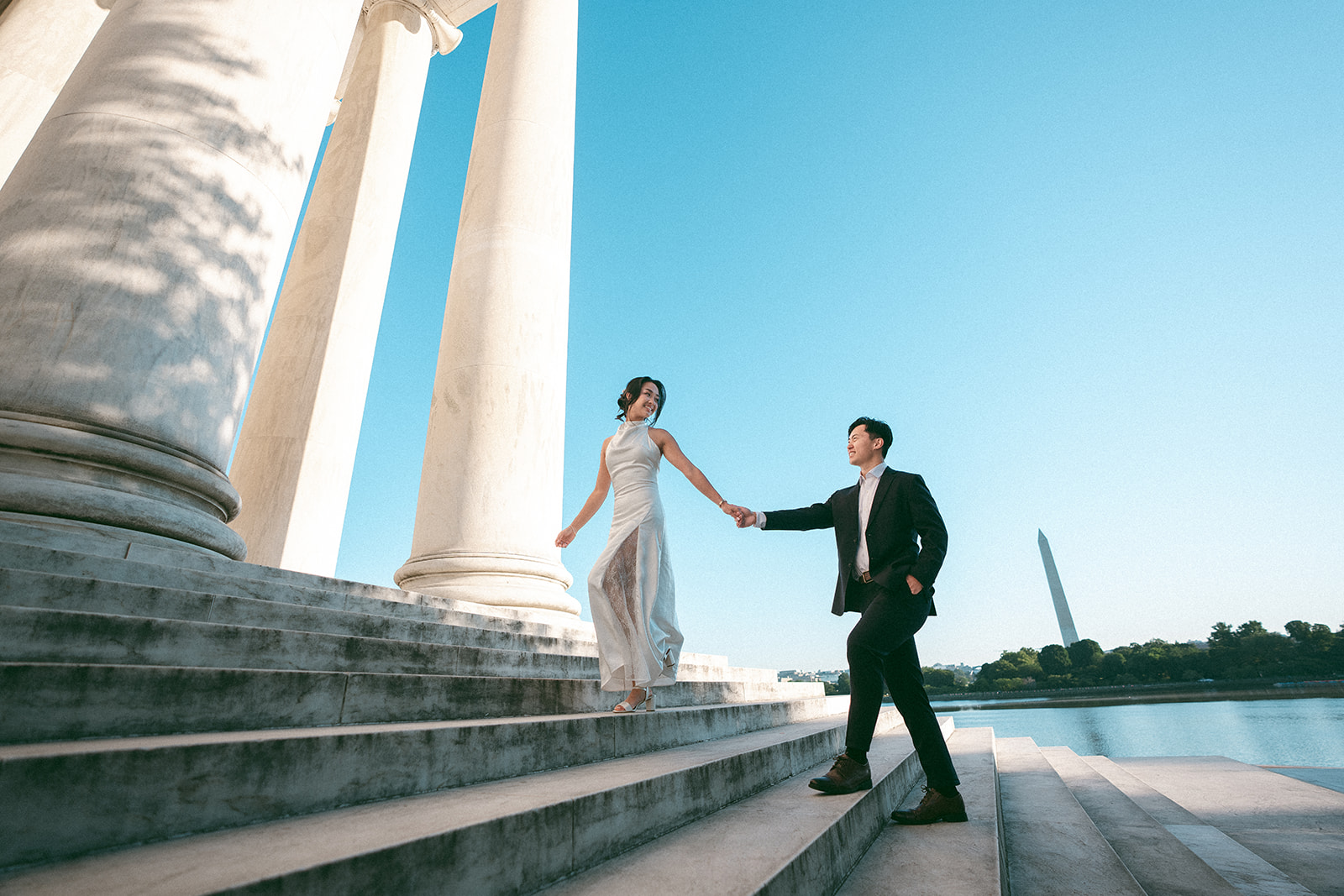 Couple walking hand in hand down the Jefferson Memorial steps during a Washington DC engagement session.