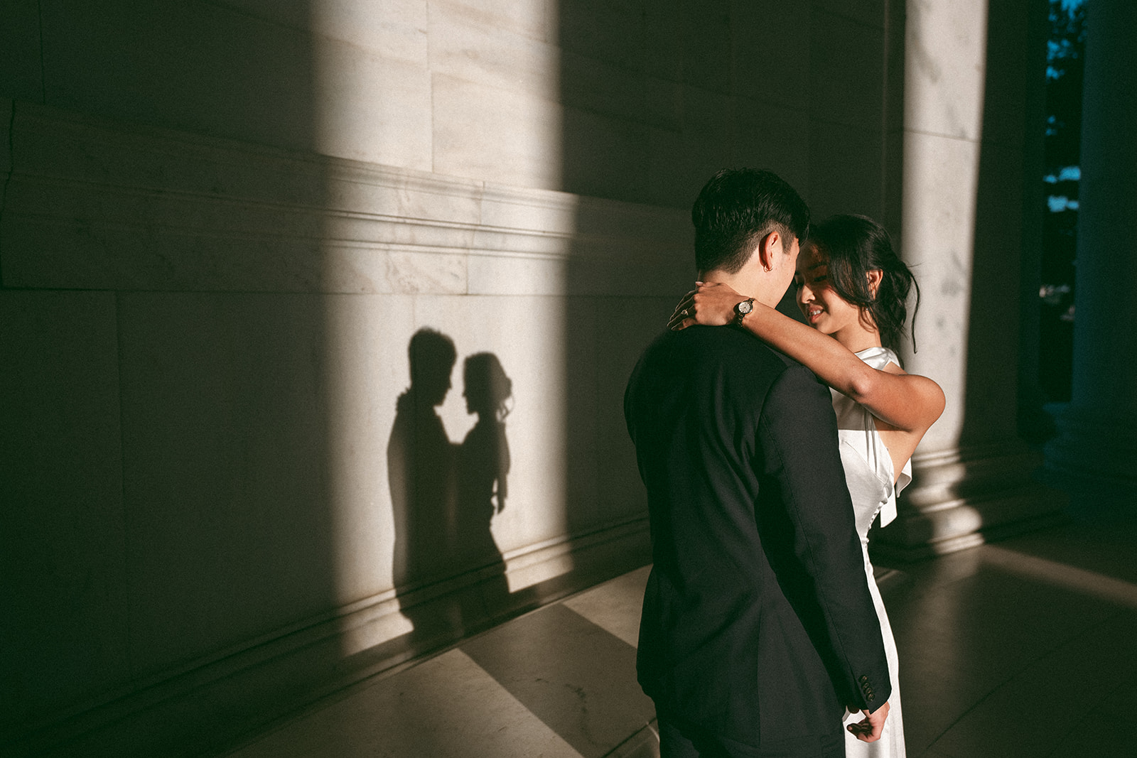 Romantic embrace with the couple's shadow cast across the Jefferson Memorial wall.