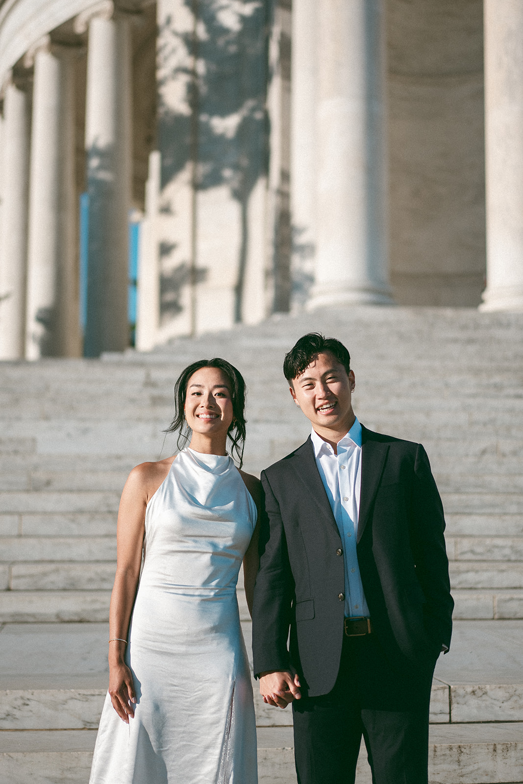 Smiling couple standing together on the Jefferson Memorial steps during a Washington DC engagement session.