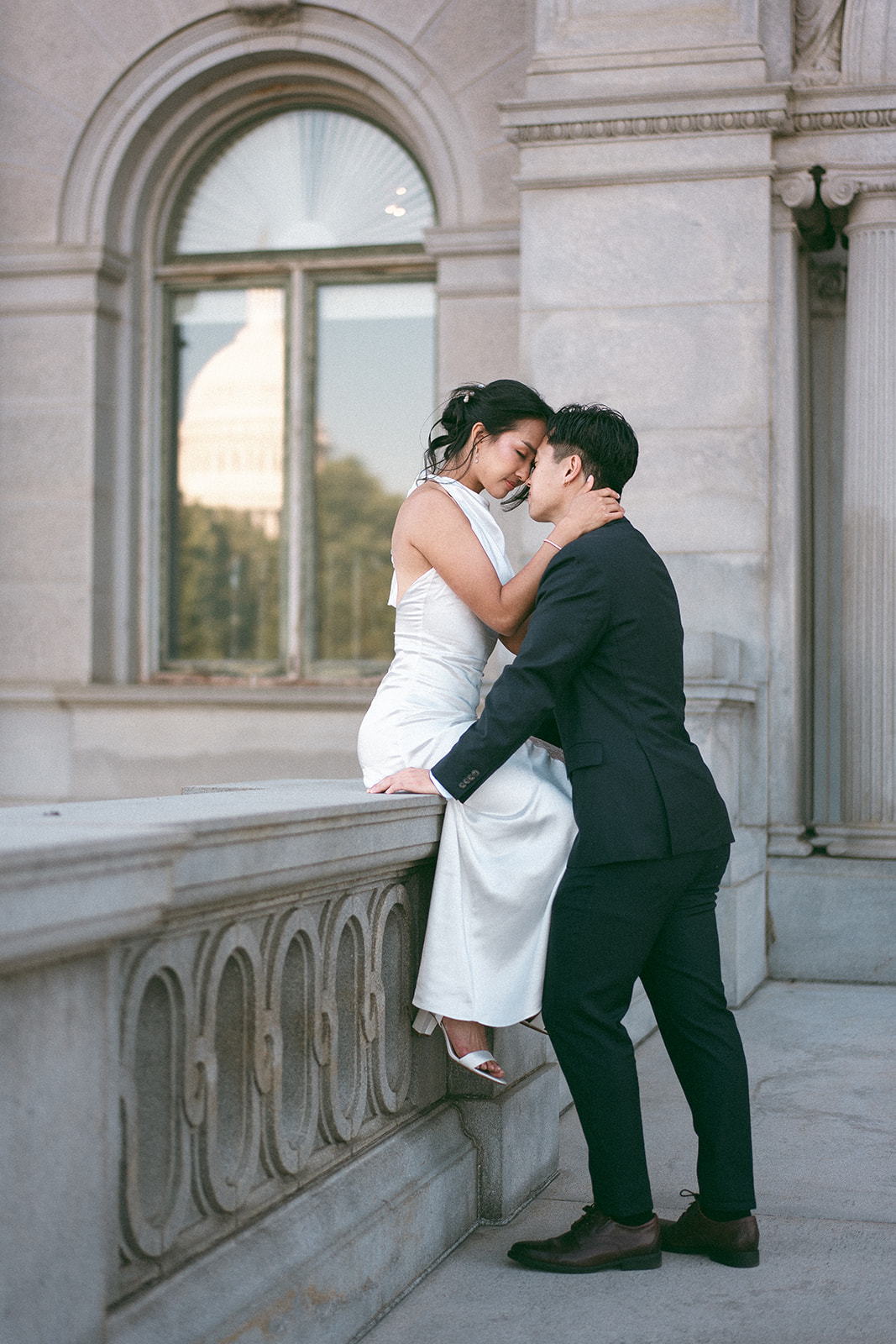 Intimate portrait of the couple embracing outside the Library of Congress during their Washington DC engagement session.