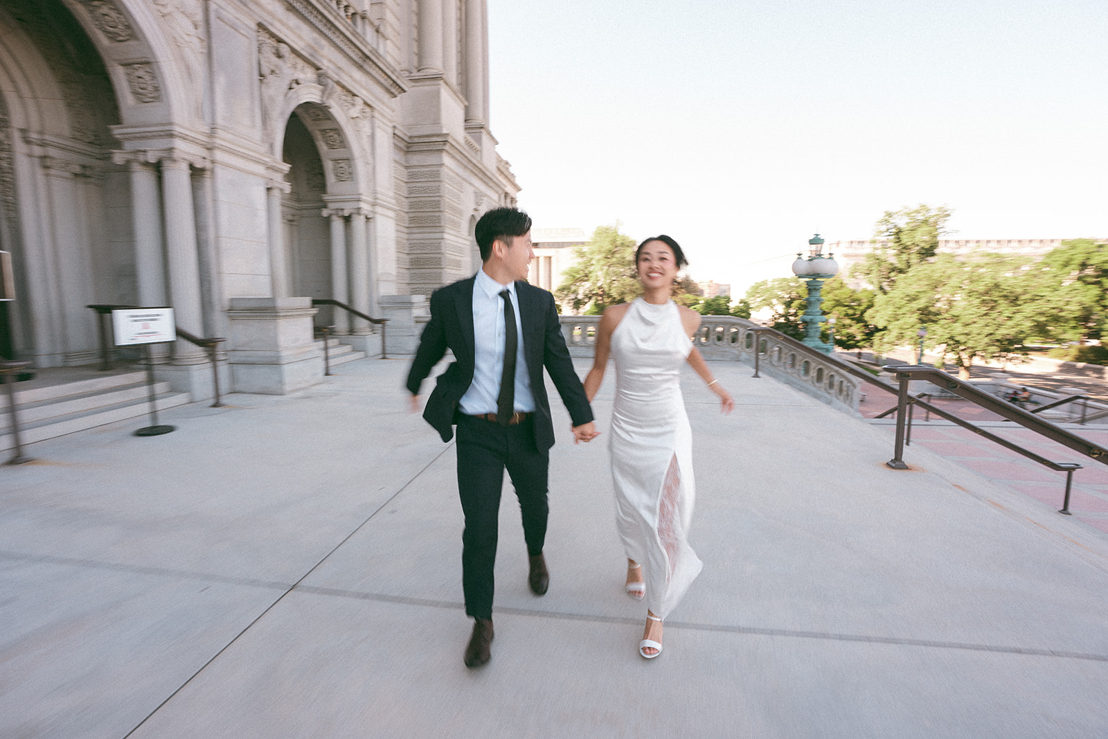 Couple running together outside the Library of Congress during their Washington DC engagement session.