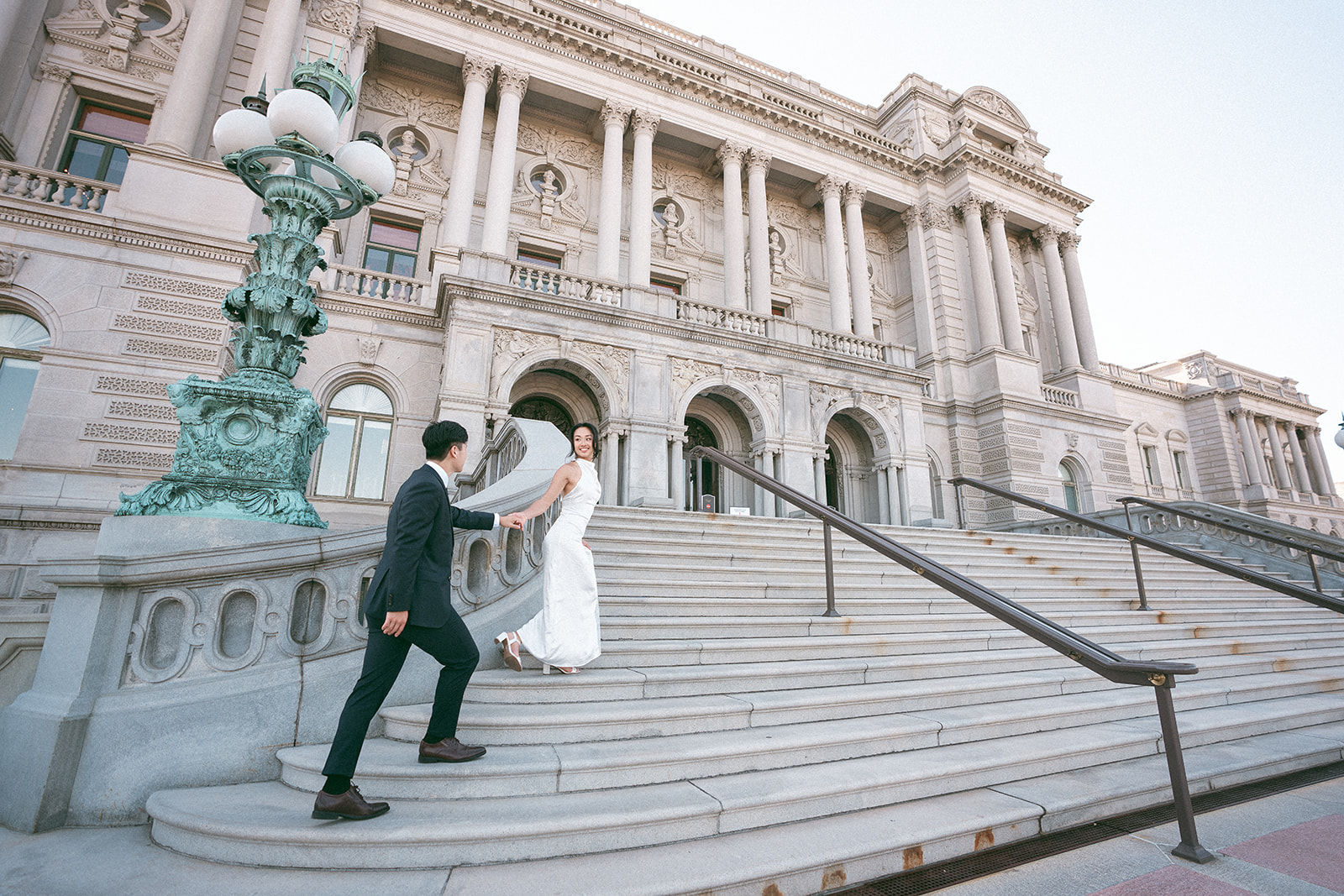 Couple walking up the Library of Congress steps hand in hand.
