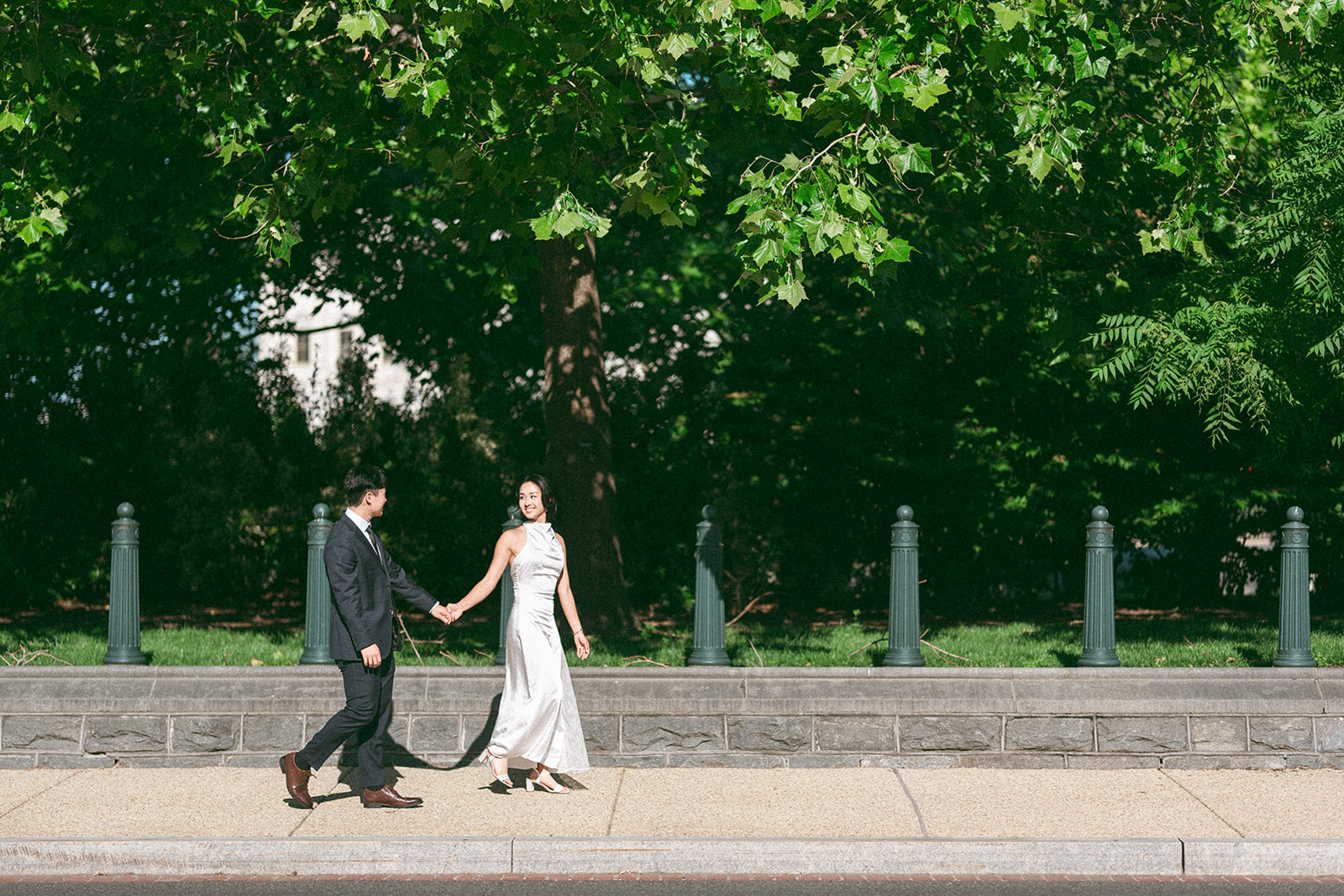 Couple strolling together beneath the trees near the National Mall.