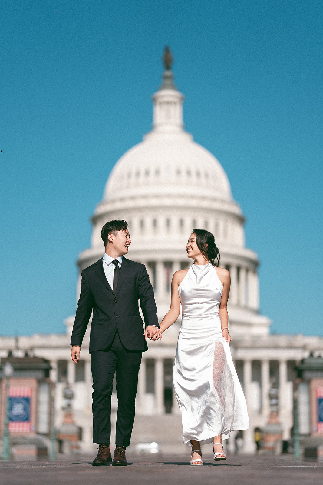 Couple holding hands in front of the U.S. Capitol during a Washington DC engagement session.
