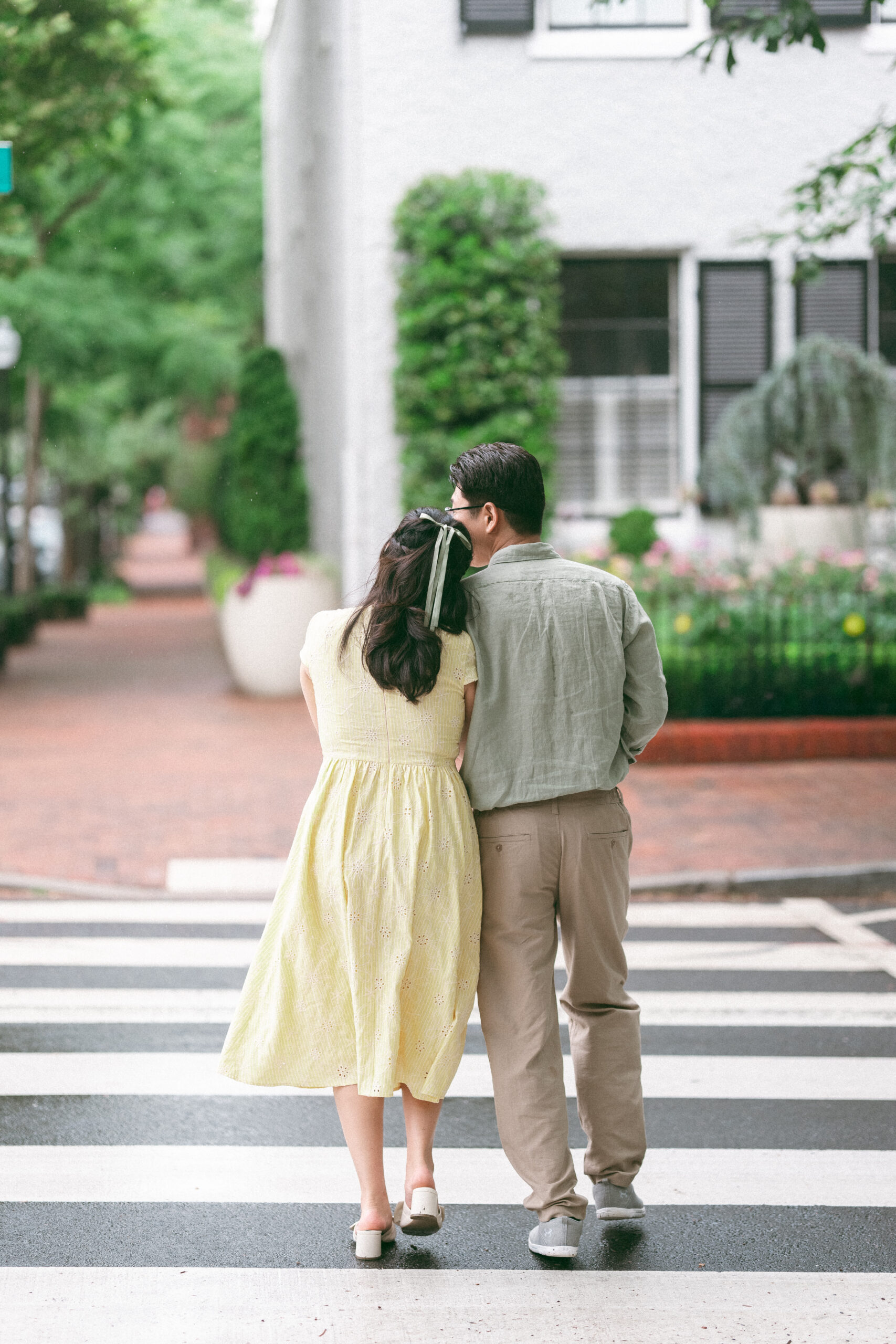 Couple walking arm in arm across a crosswalk after the rain.