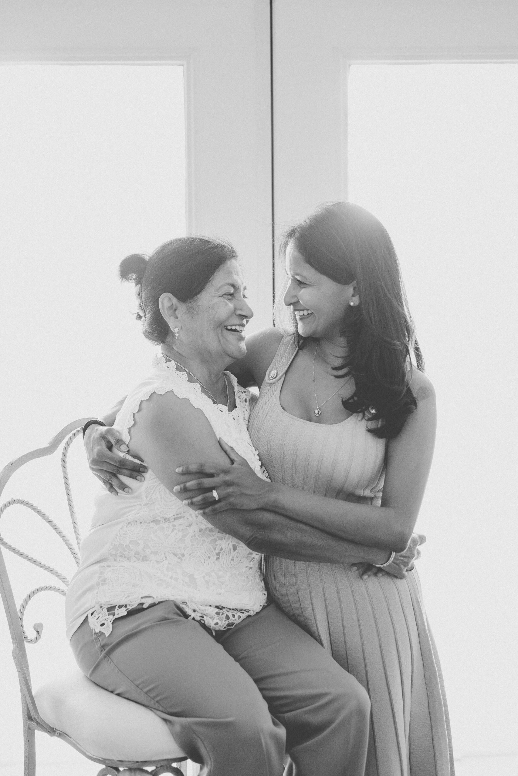Black and white portrait of a mother and grandmother smiling at one another during a Maryland family photoshoot.