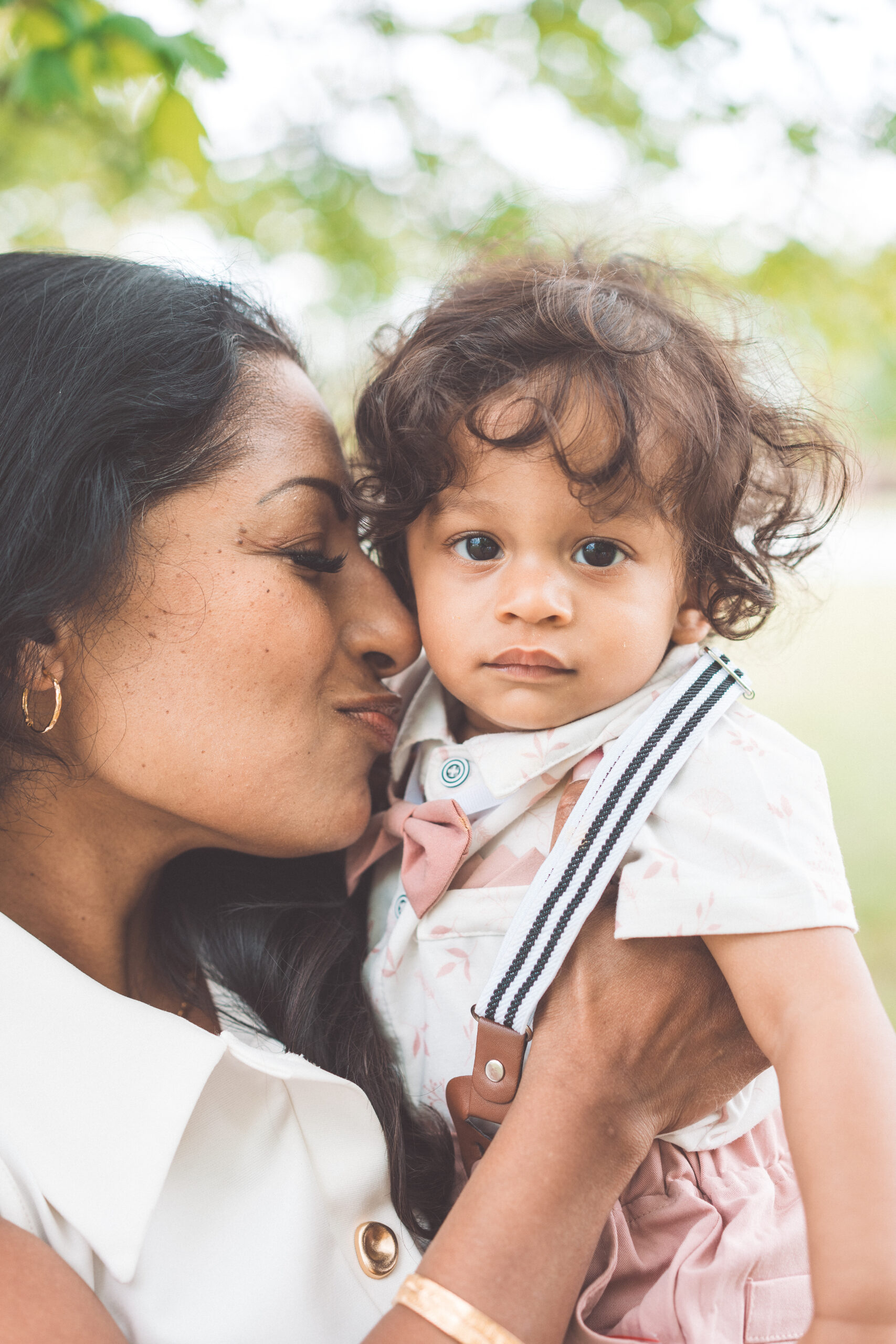 Mother kissing her toddler's cheek while holding them close during a Maryland family photoshoot.