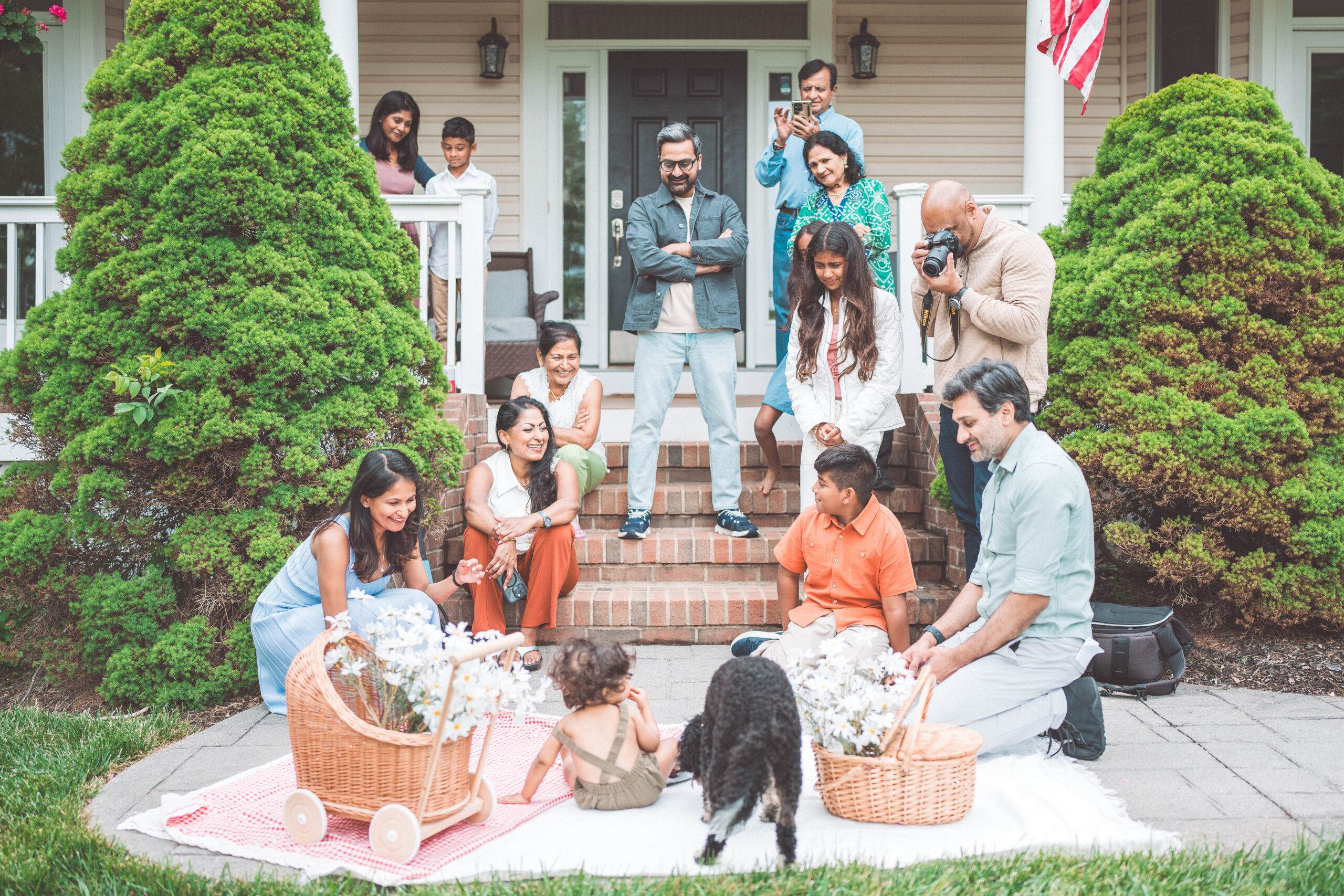 Extended family gathering together for a first birthday picnic celebration in the backyard during a Maryland family photoshoot.