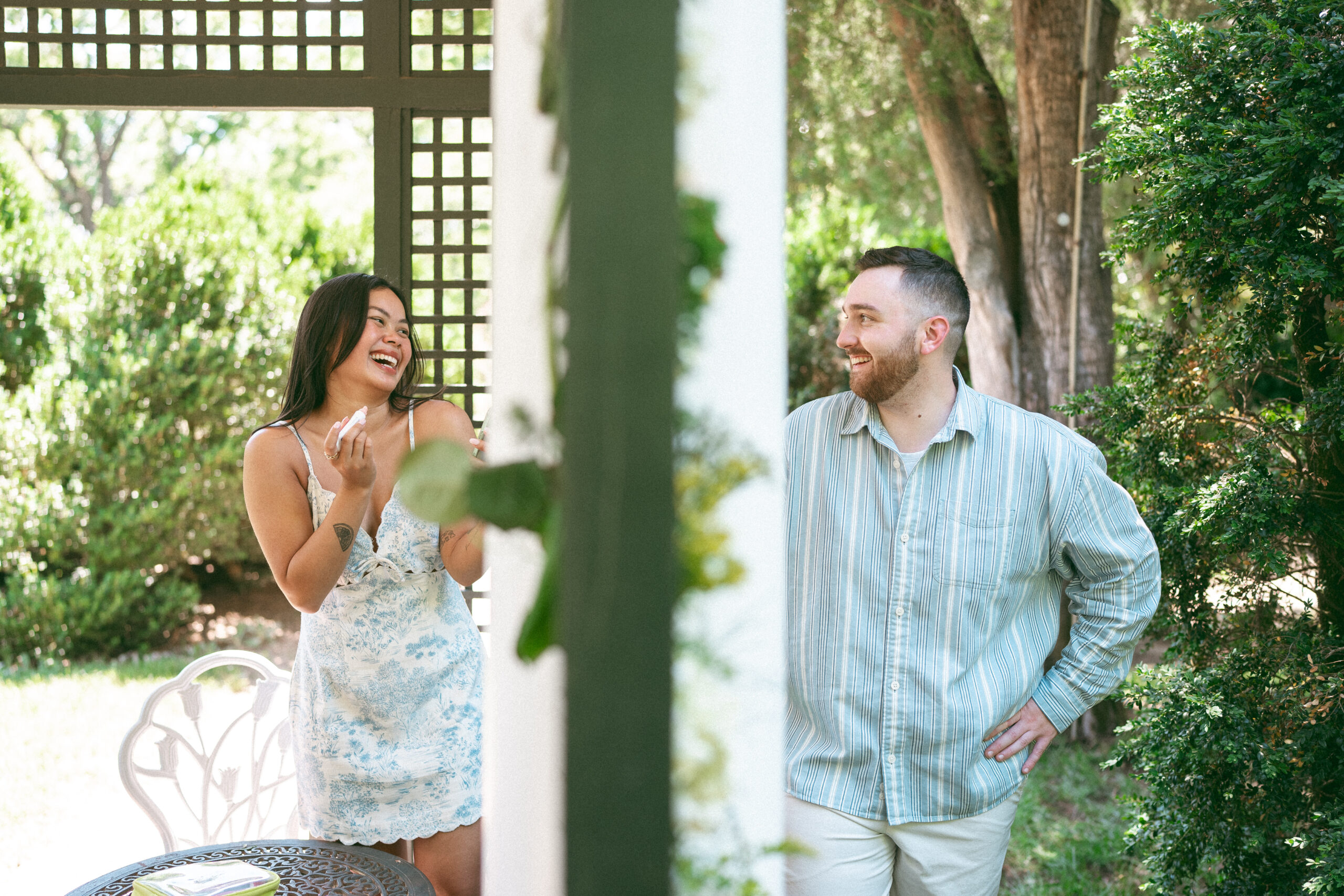 Newly engaged couple laughing together after the surprise proposal.