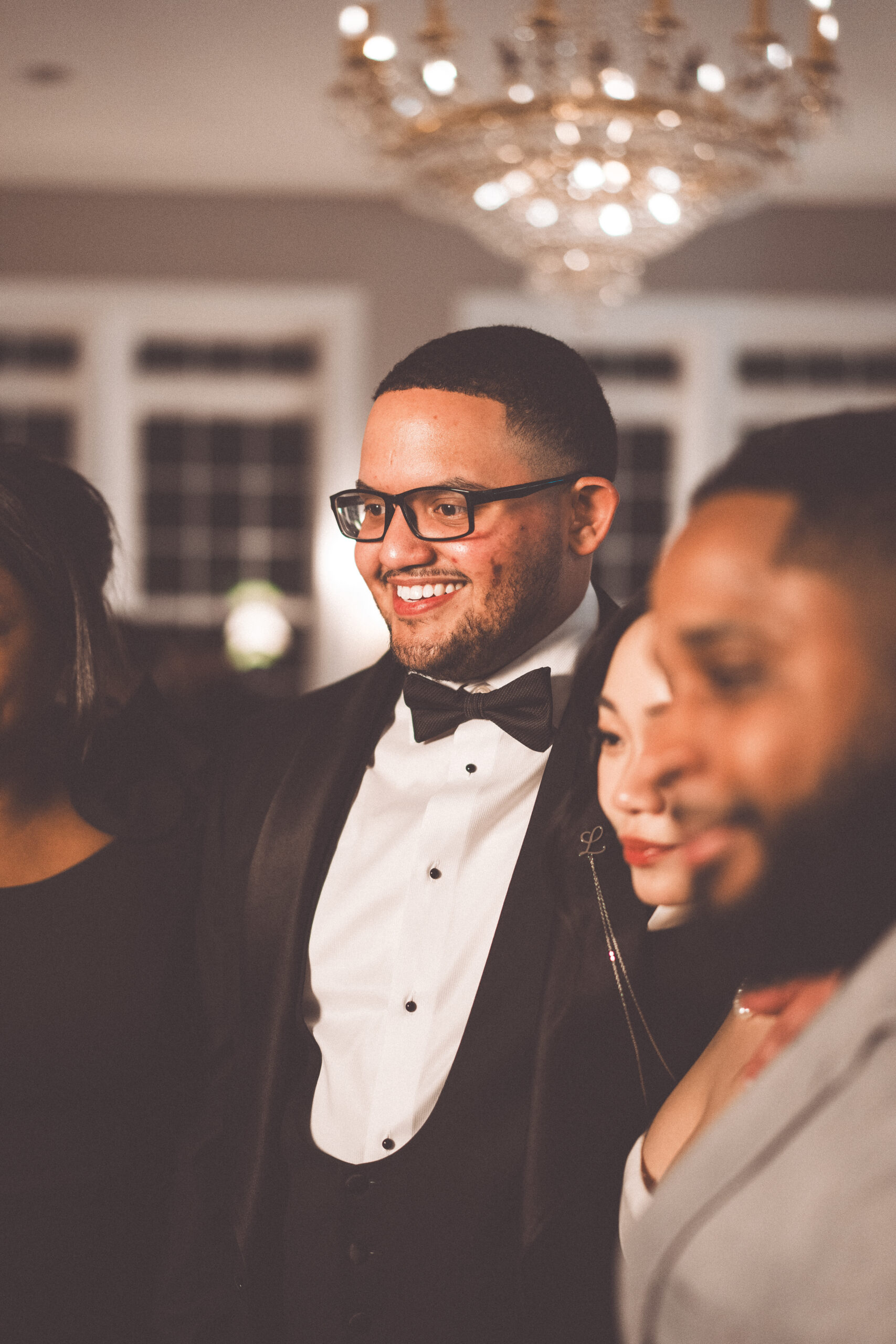 Groom smiling with wedding guests during the reception at Cameron Estate Inn.