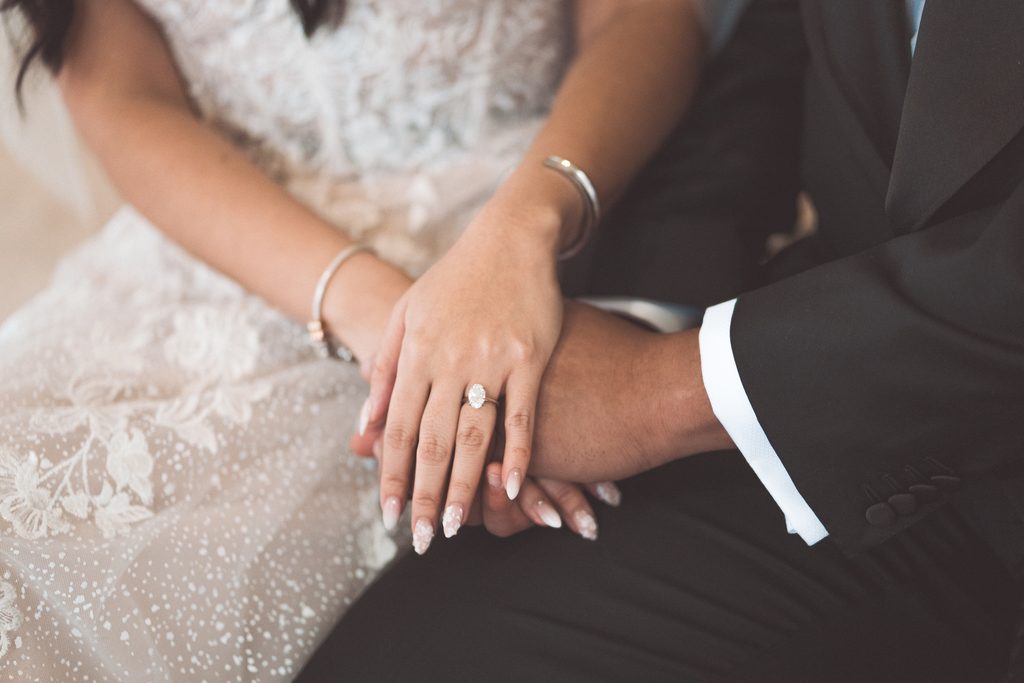 Close-up of the bride-to-be’s engagement ring as the couple holds hands during their Jefferson Memorial engagement photos.