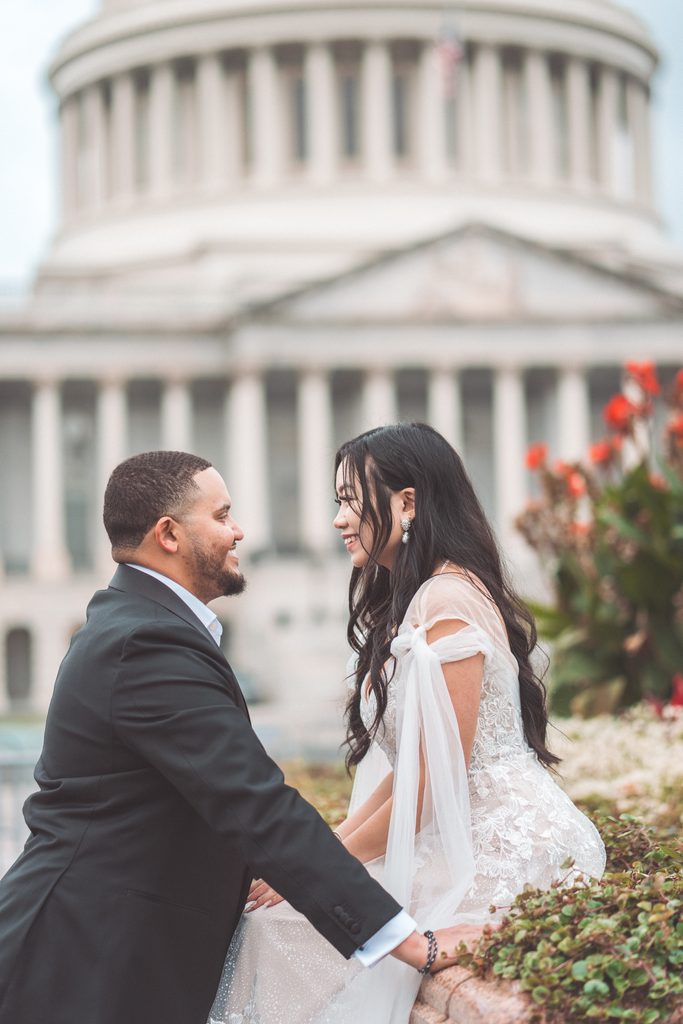 Couple smiling at each other during Jefferson Memorial engagement photos with classic Washington DC architecture in the background.