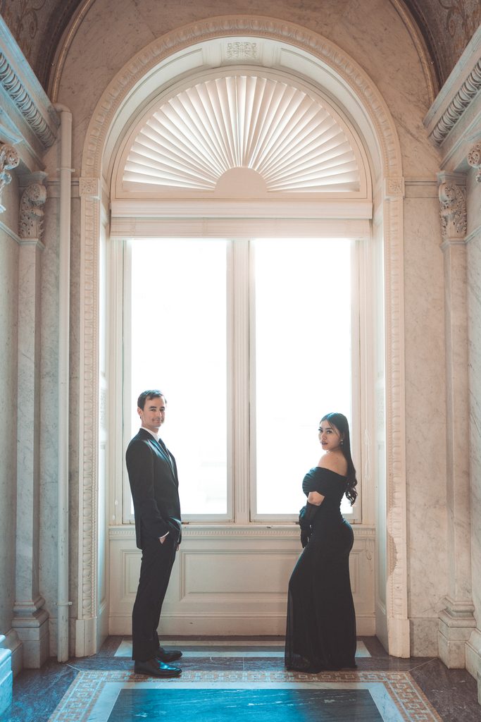 Couple posing in front of a bright window during their Library of Congress Engagement Photos.