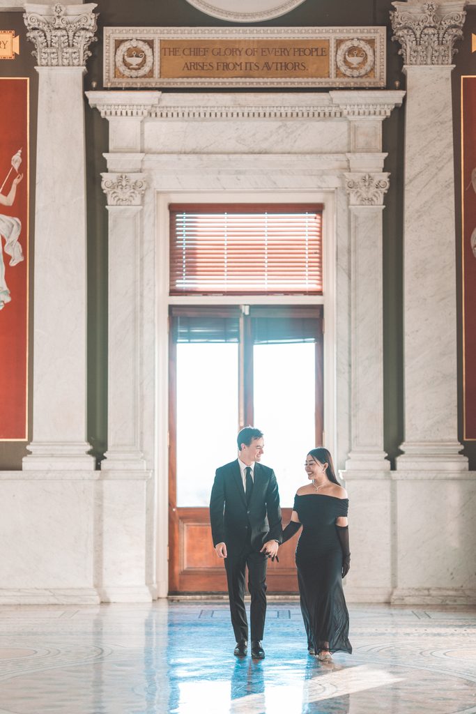 Couple walking hand in hand through the grand marble interior during their Library of Congress Engagement Photos.