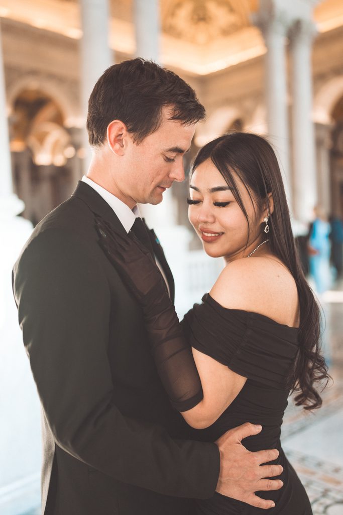 Close-up engagement portrait of a couple embracing inside the ornate Library of Congress interior.