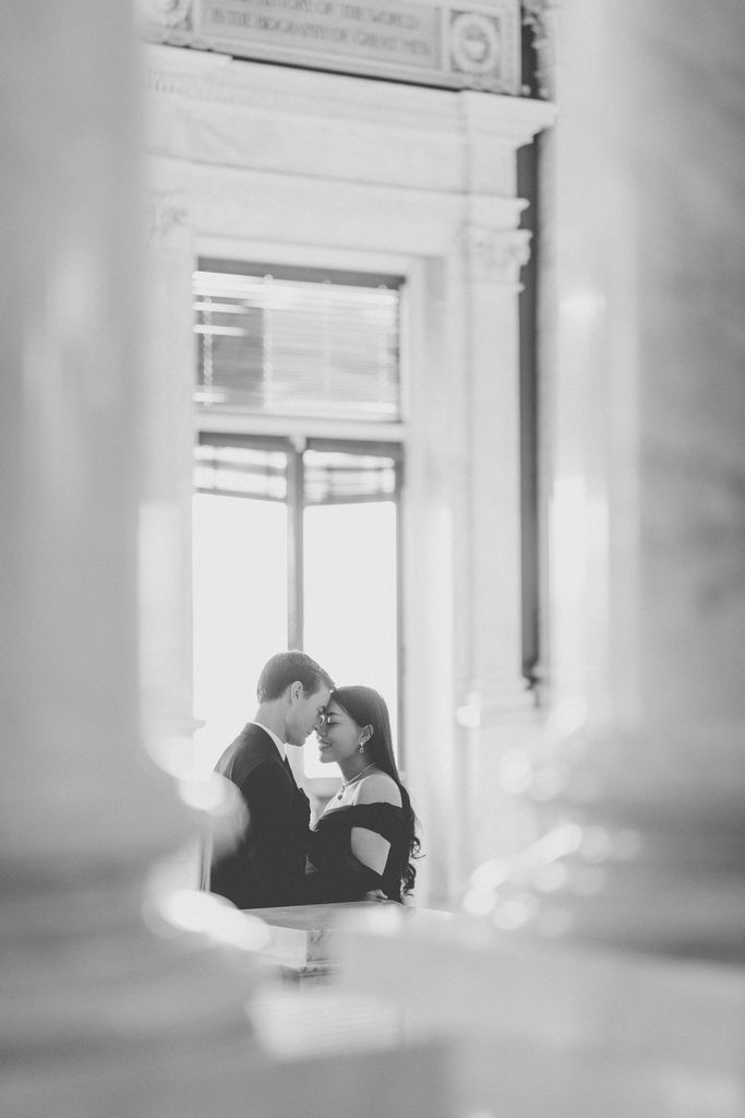 Black and white Library of Congress Engagement Photos of a couple sharing a quiet moment framed by the building's architecture.