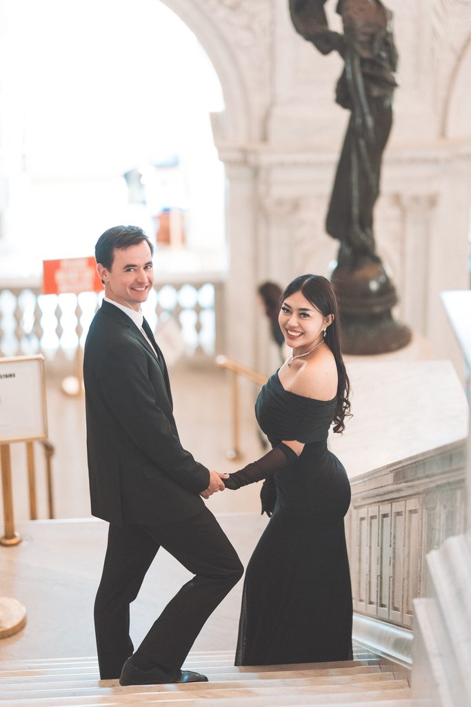 Couple holding hands on the grand staircase during their Library of Congress Engagement Photos in Washington DC.