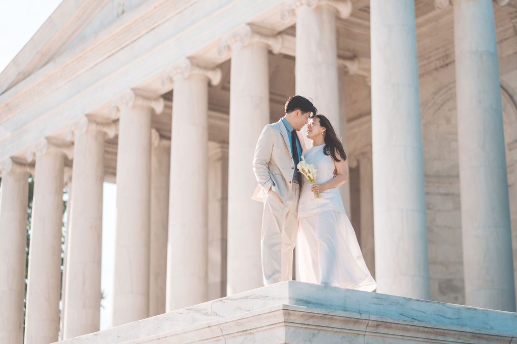 National Gallery of Art engagement photos of a couple standing together beneath the grand exterior columns in Washington DC.