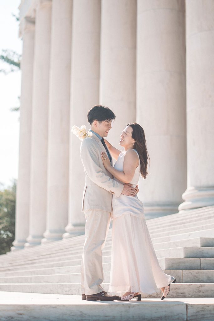 Couple embracing and smiling on the marble steps outside the National Gallery of Art.