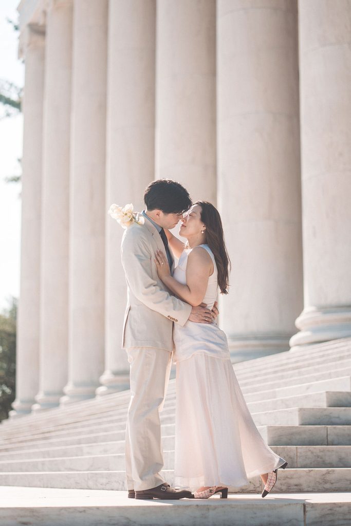 Couple kissing on the marble steps between the National Gallery of Art’s grand exterior columns.
