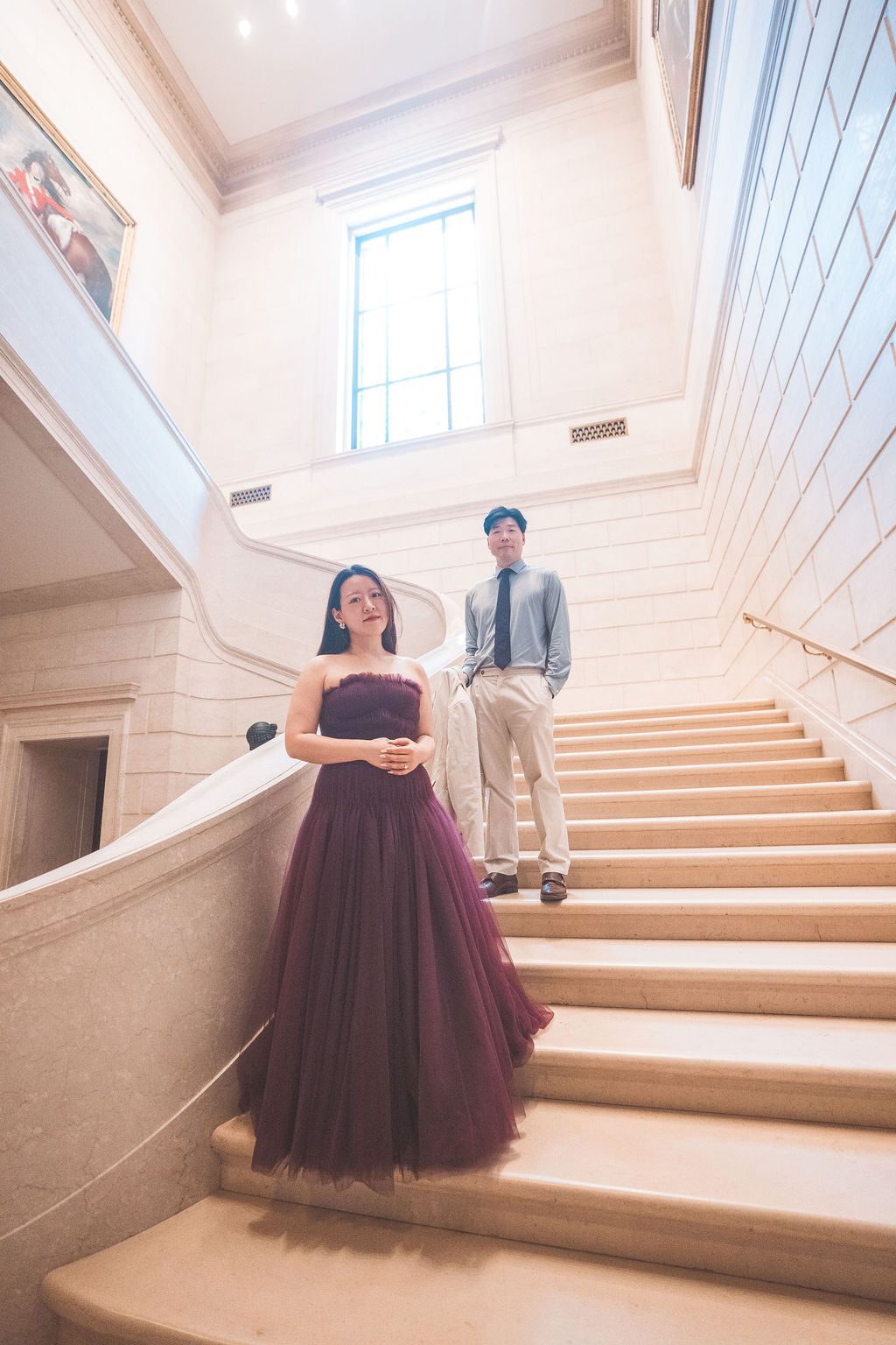 Couple posing together on a grand marble staircase inside the National Gallery of Art.