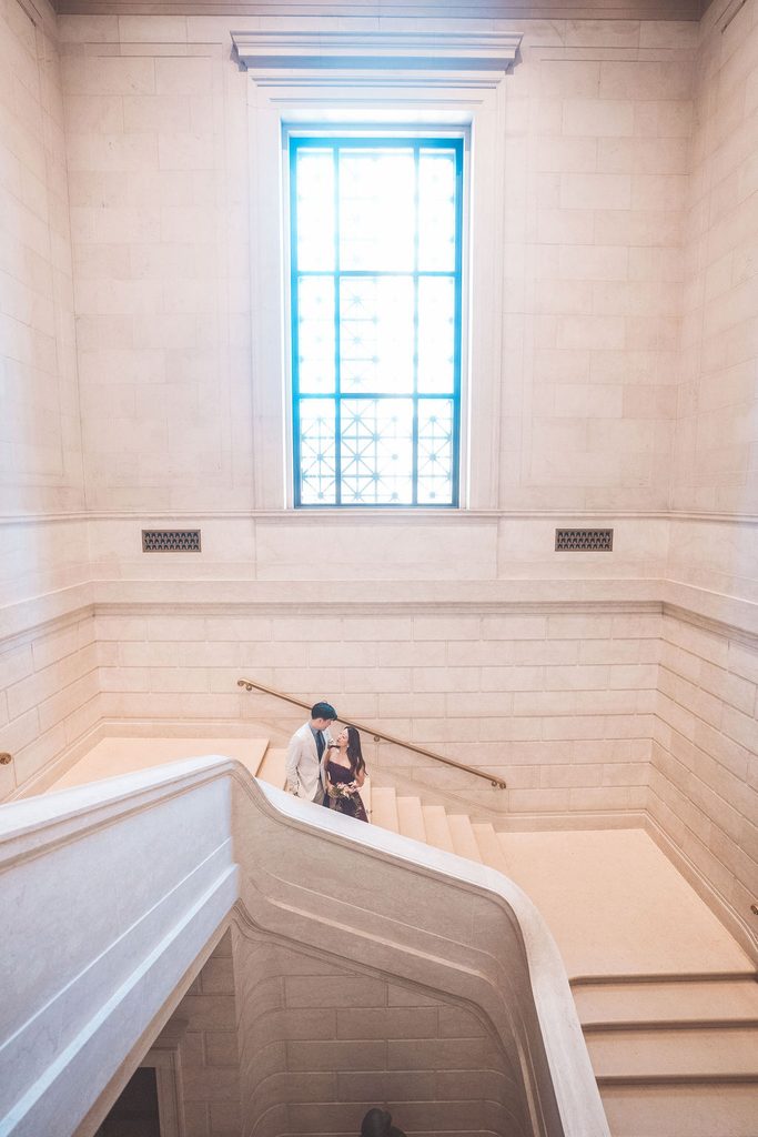 National Gallery of Art engagement photos of a couple sharing a quiet moment on the museum’s sweeping marble staircase.