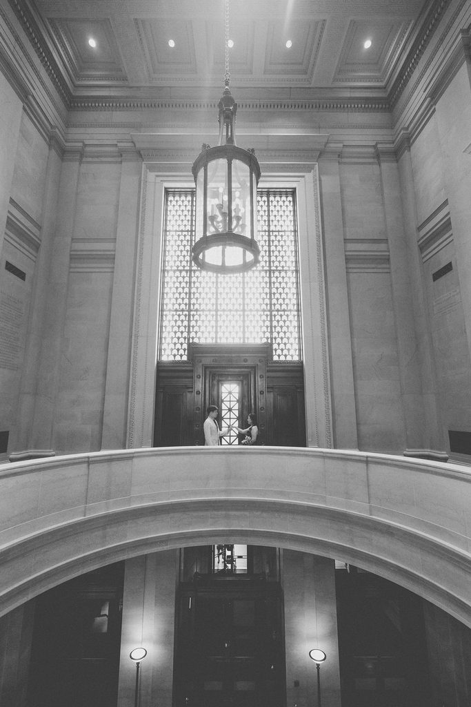A black and white photo of a couple on a grand staircase at the National Gallery of Art in Washington, DC.