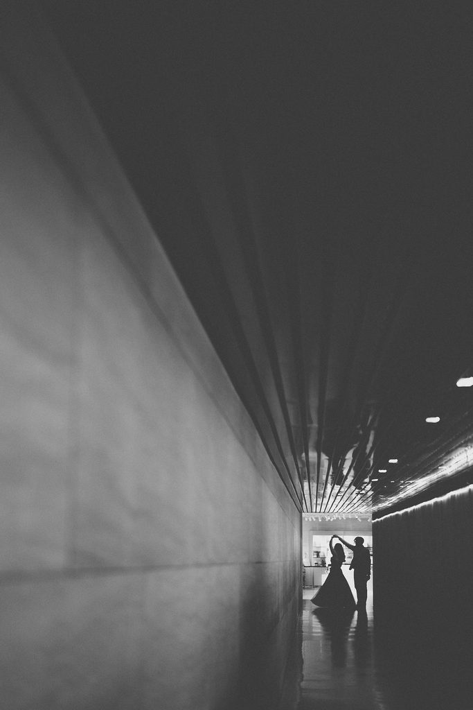 National Gallery of Art engagement photos featuring a black-and-white silhouette of a couple at the end of a modern museum hallway.