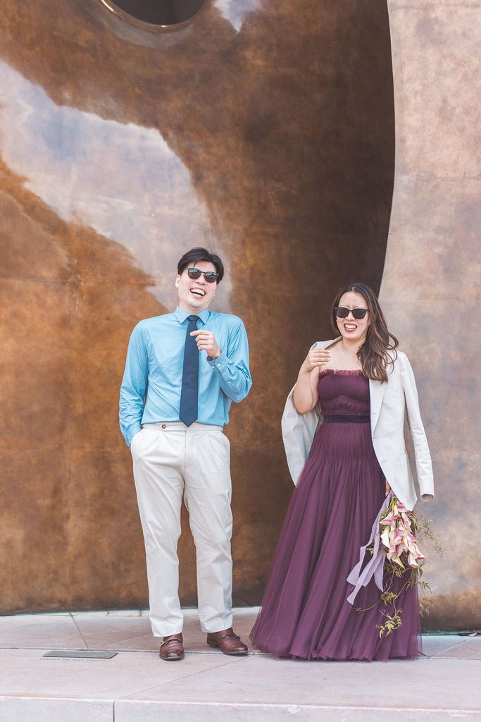National Gallery of Art engagement photos of a couple laughing together in formal outfits beside a large abstract artwork.